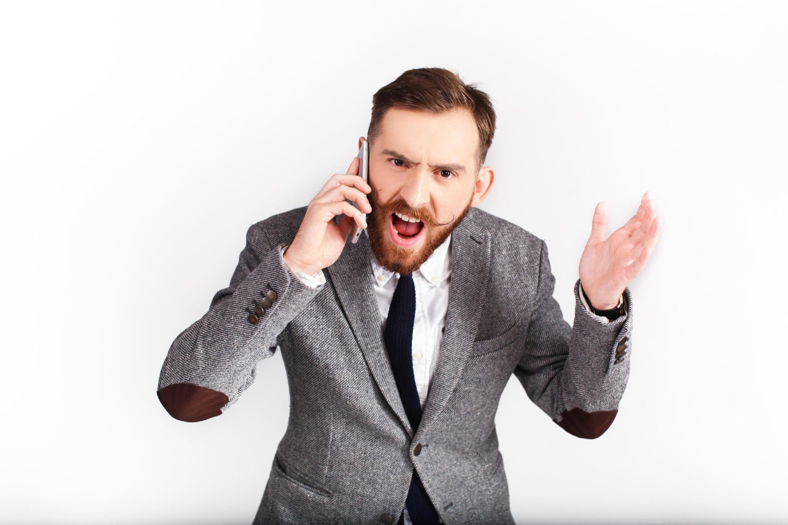 uomo-arrabbiato-in-abito-grigio-parla-al-telefono